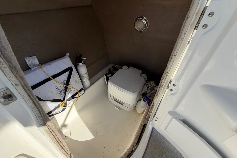 Slide: The Image of Interior of 2021 NauticStar 223 DC boat with portable toilet and safety equipment. - 18