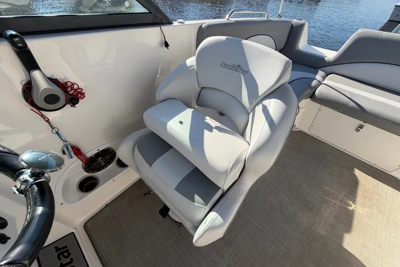 Slide: The Image of 2021 NauticStar 223 DC boat interior with plush seating and steering wheel. - 12