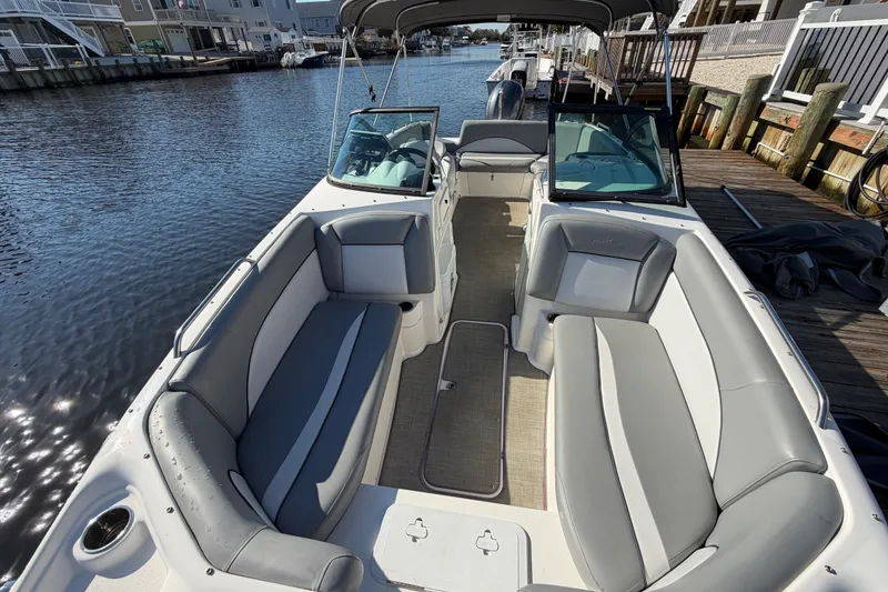 Slide: The Image of 2021 NauticStar 223 DC boat with spacious seating, docked by a serene waterfront. - 22