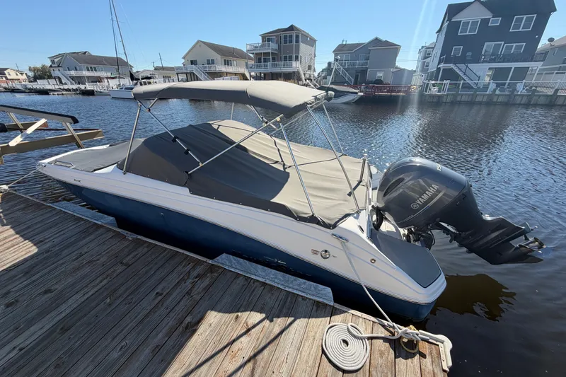 Slide: The Image of 2021 NauticStar 223 DC boat docked with Yamaha outboard motor, covered and ready for use. - 7