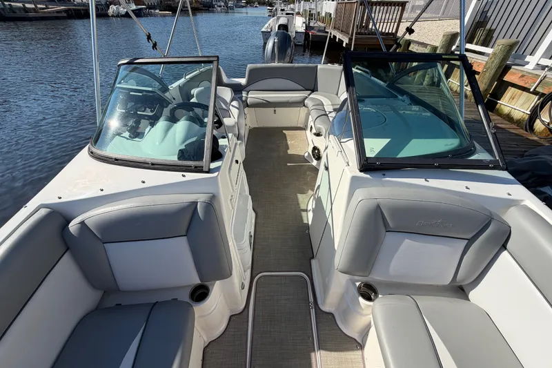 Slide: The Image of 2021 NauticStar 223 DC boat interior with gray seating and dual consoles. - 23