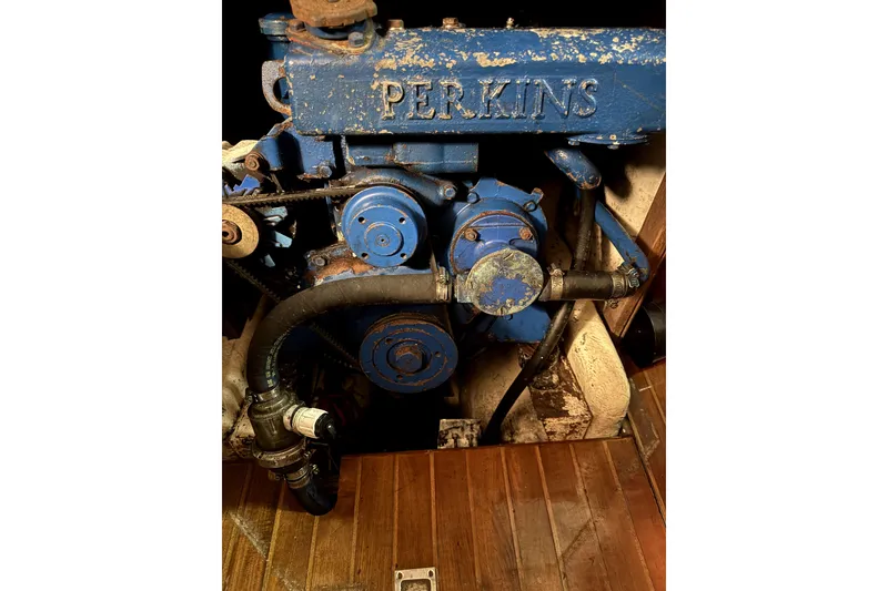 Slide: The Image of Perkins engine in a 1979 Tayana 37 sailboat, showing blue machinery and hoses. - 29