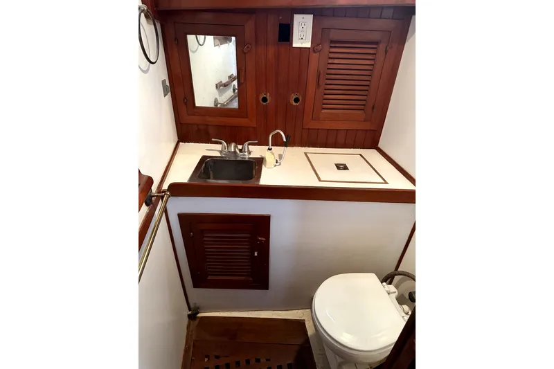 Slide: The Image of 1979 Tayana 37 yacht bathroom with wooden cabinetry, sink, and toilet. - 19