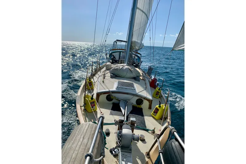 Slide: The Image of Sailing on a 1979 Tayana 37 yacht, gliding through sparkling ocean waters. - 3