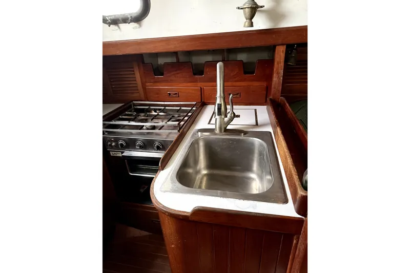 Slide: The Image of 1979 Tayana 37 yacht galley with stainless steel sink and stove. - 14