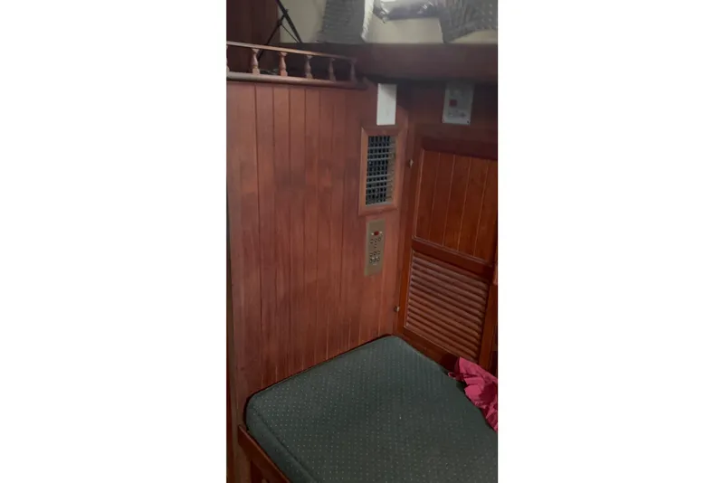Slide: The Image of Interior of 1979 Tayana 37 sailboat with wooden paneling and cushioned seating. - 23