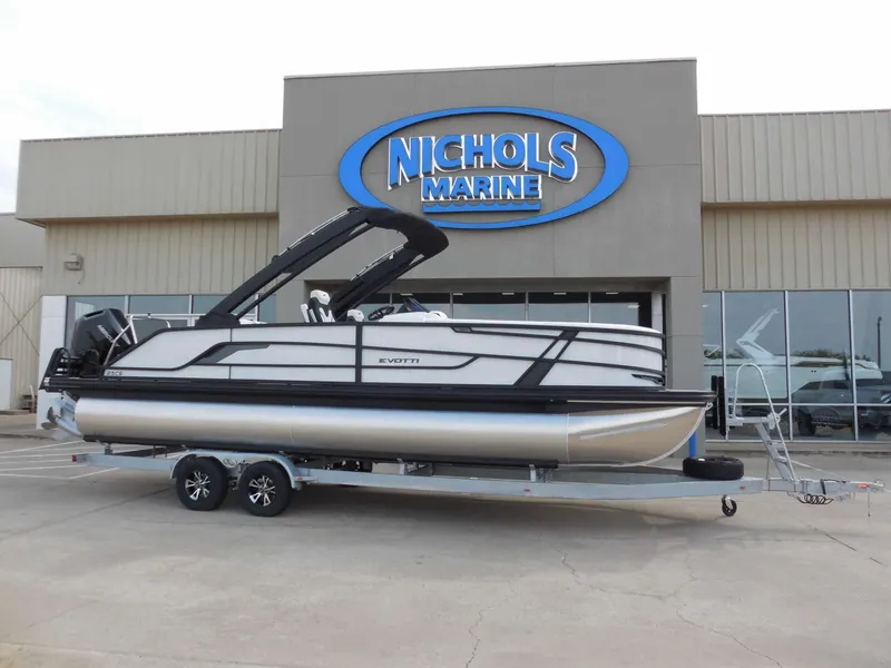 The Image of An Evotti 725 CS Arch Tri Toon from 2027 is on a trailer outside a marine store. - 0