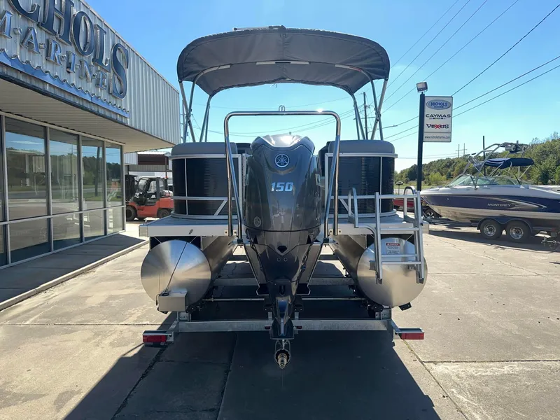 Slide: The Image of A 2027 Bennington 22 SSR pontoon boat with a 150 HP engine, parked in front of a building. - 3