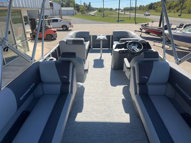 Slide: The Image of The image shows the interior of a Bennington 22 SSR pontoon boat with gray seating and a helm. - 4