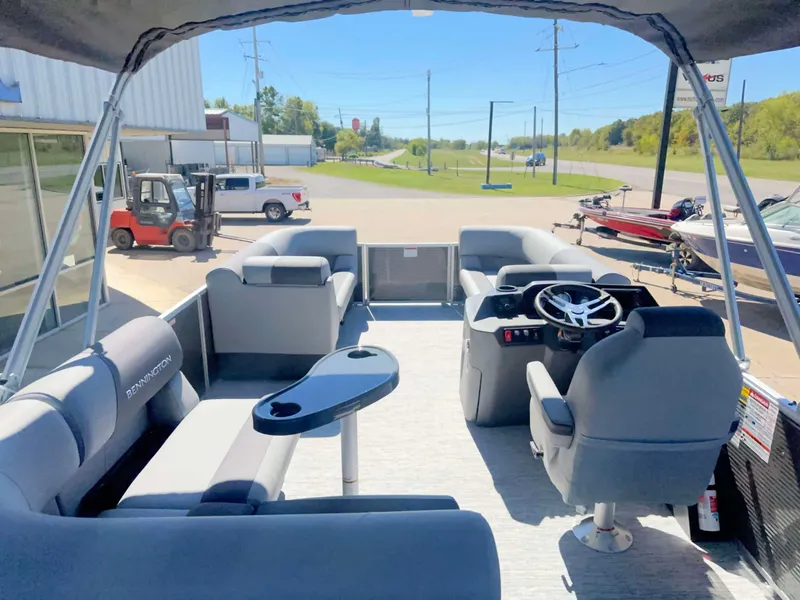 Slide: The Image of The image shows the interior of a Bennington 22 SFC pontoon boat with gray seating and a helm. - 4