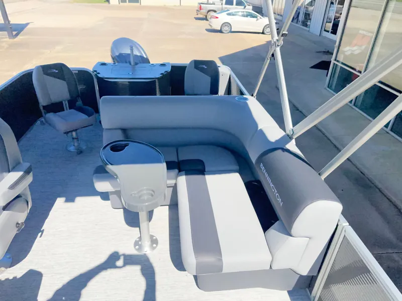 Slide: The Image of The image shows the deck of a Bennington 22 SFC pontoon boat with gray seating and a table. - 10