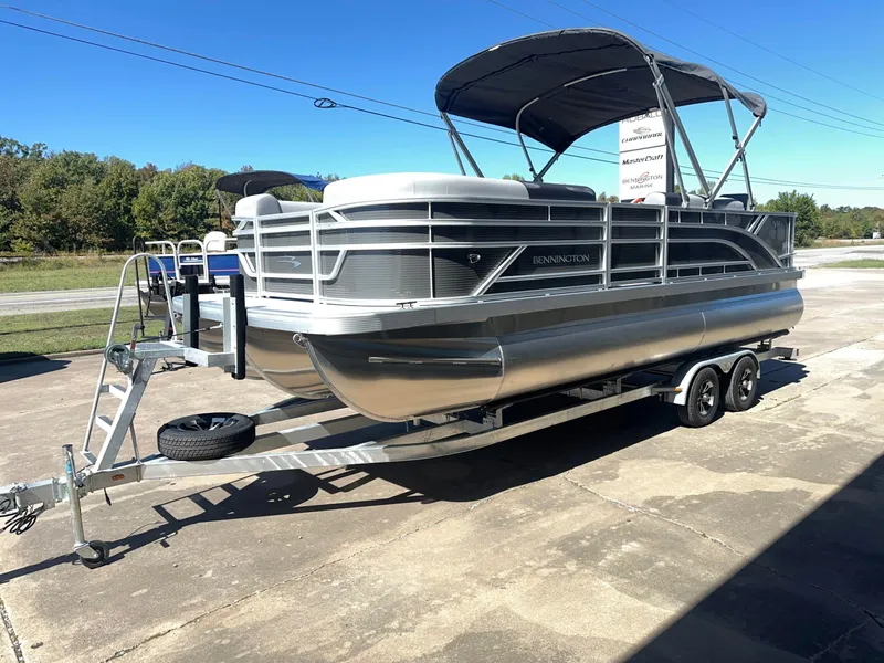 Slide: The Image of A 2027 Bennington 22 SFC pontoon boat on a trailer. It features a black canopy. - 2