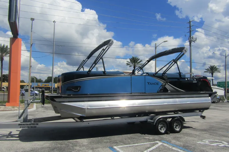 Slide: The Image of 2026 Tahoe Pontoon LTZ Cruise Rear Bench 23 on trailer under blue sky. - 7