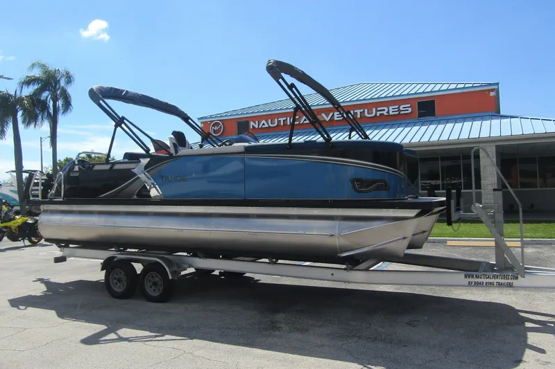 Slide: The Image of Un Tahoe Pontoon LTZ Cruise Rear Bench 23 bleu de 2026 sur une remorque devant un bâtiment. - 6