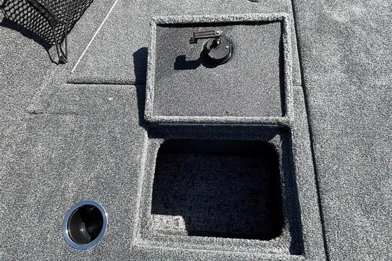 Slide: The Image of The image shows a gray boat deck with an open storage compartment and a cup holder. - 23