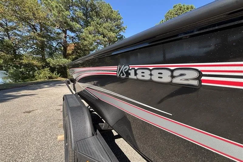 Slide: The Image of 2026 Ranger VS1882SC Angler boat with sleek black and red design on a trailer. - 36