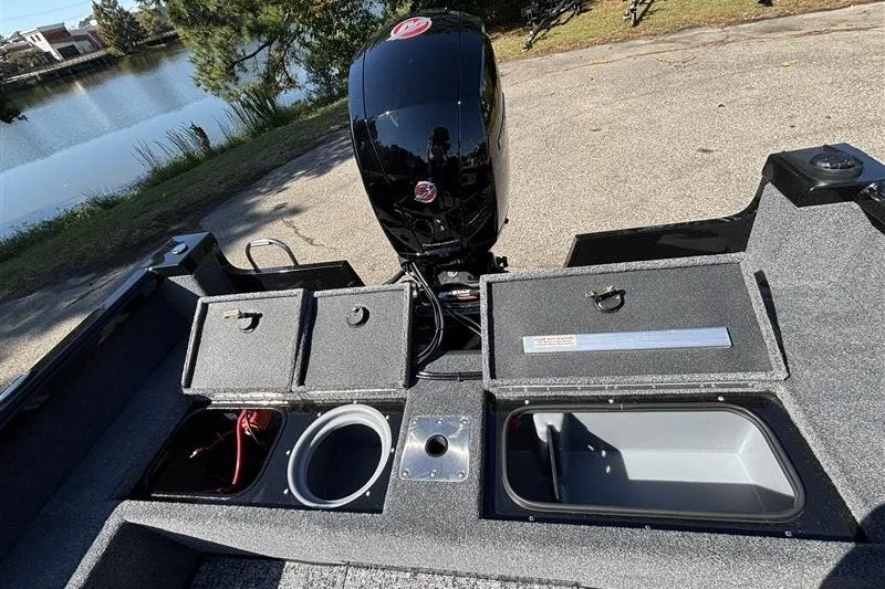 Slide: The Image of 2026 Ranger VS1882SC Angler boat with open storage compartments and motor by a lake. - 34