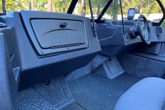 Slide: The Image of Interior of 2027 Tracker Pro Guide V-16 WT boat, featuring modern dashboard and seating. - 16