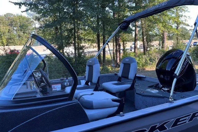 Slide: The Image of 2027 Tracker Pro Guide V-16 WT boat interior with seating and motor, surrounded by trees. - 15