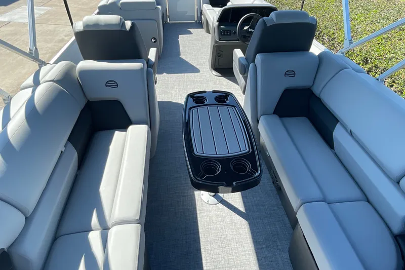 Slide: The Image of 2027 Sun Tracker Party Barge 22 DLX interior with plush seating and central table. - 17