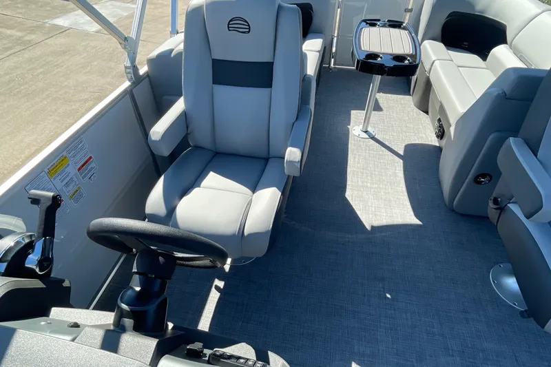 Slide: The Image of Interior of 2027 Sun Tracker Party Barge 22 DLX, featuring comfortable seating and steering controls. - 28