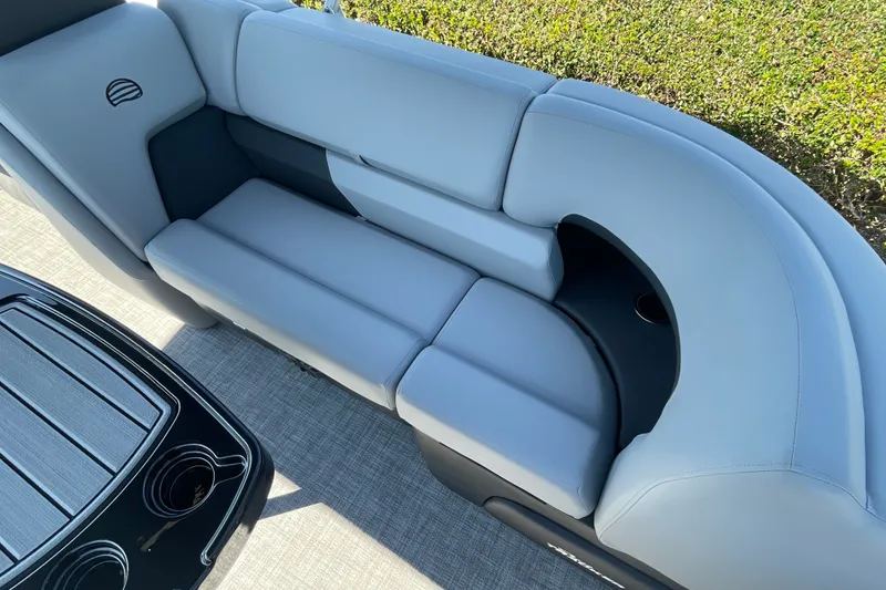 Slide: The Image of 2027 Sun Tracker Party Barge 22 DLX interior with plush seating and cup holders. - 19