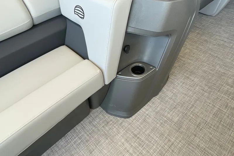 Slide: The Image of 2027 Sun Tracker Party Barge 22 DLX interior with cushioned seating and built-in cup holder. - 13