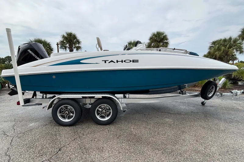 Slide: The Image of 2027 Tahoe 2150 CC boat on trailer, blue and white design, parked outdoors. - 1