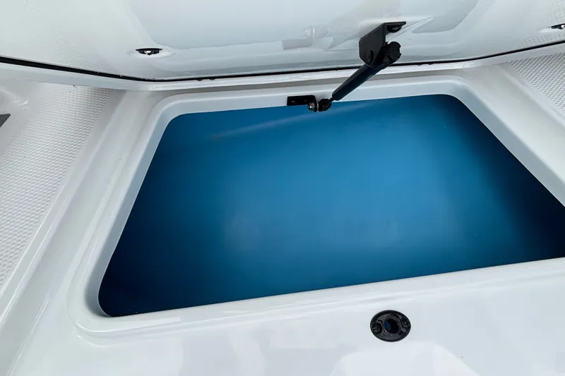 Slide: The Image of Open storage compartment in 2027 Tahoe 2150 CC boat, featuring a blue interior. - 12