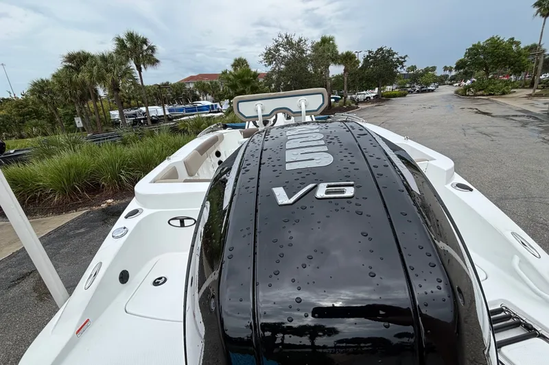 Slide: The Image of 2027 Tahoe 2150 CC boat with V6 engine, parked near palm trees on a wet day. - 13
