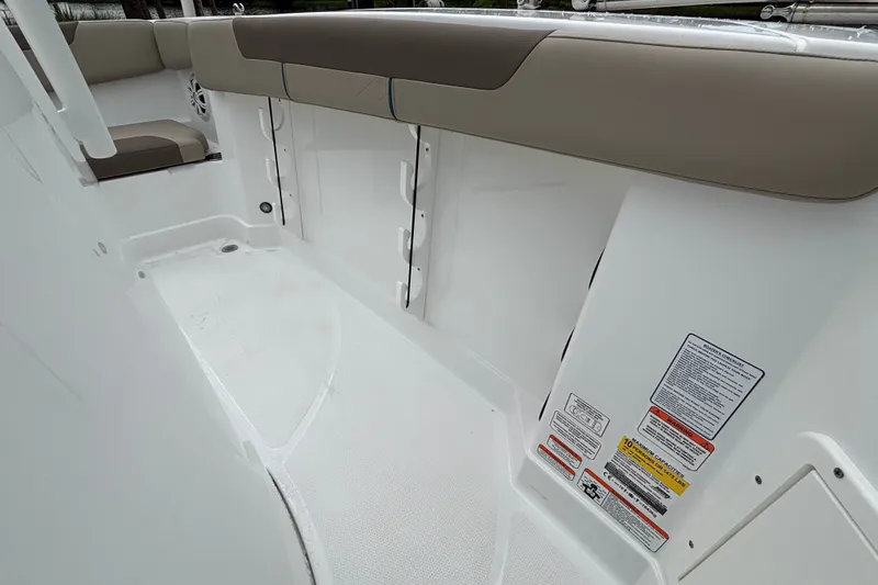 Slide: The Image of 2027 Tahoe 2150 CC boat interior with cushioned seating and safety labels. - 8