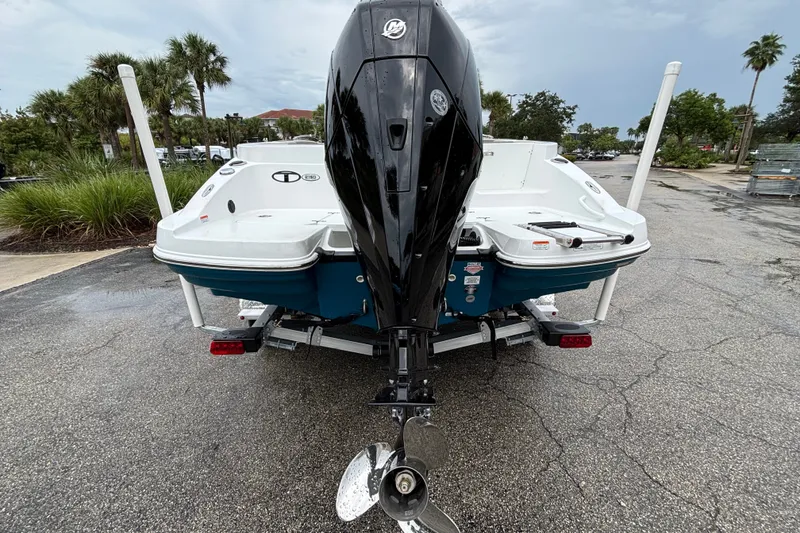Slide: The Image of 2027 Tahoe 2150 CC boat with outboard motor on a trailer, parked outdoors. - 4