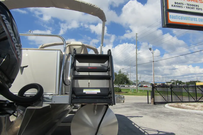 Slide: The Image of 2026 Tahoe Pontoon Sport 85 Rear Fish 21 with Mercury engine, docked under blue sky. - 2