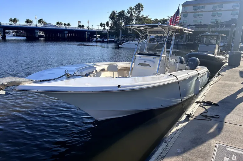 The Image of 2010 Key West 244 Center Console boat docked at marina under clear blue sky. - 1