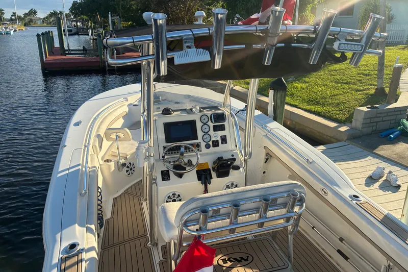 Slide: The Image of 2010 Key West 244 Center Console boat docked, featuring a sleek helm and fishing rod holders. - 13