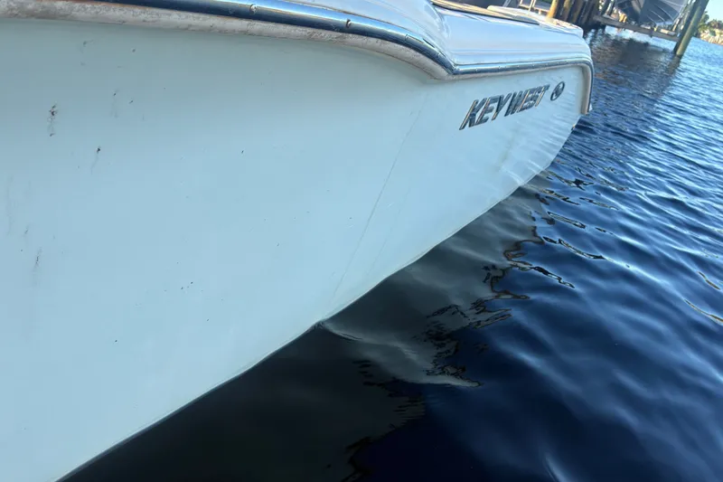 Slide: The Image of 2010 Key West 244 Center Console boat on calm water, side view. - 48