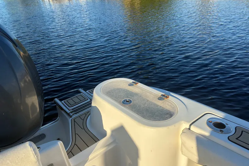 Slide: The Image of 2010 Key West 244 Center Console boat on calm water, showcasing deck and motor. - 36