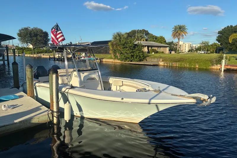 The Image of 2010 Key West 244 Center Console boat docked on a sunny day with American flag. - 0
