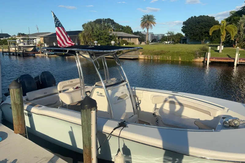 Slide: The Image of 2010 Key West 244 Center Console boat docked by a scenic waterfront. - 27