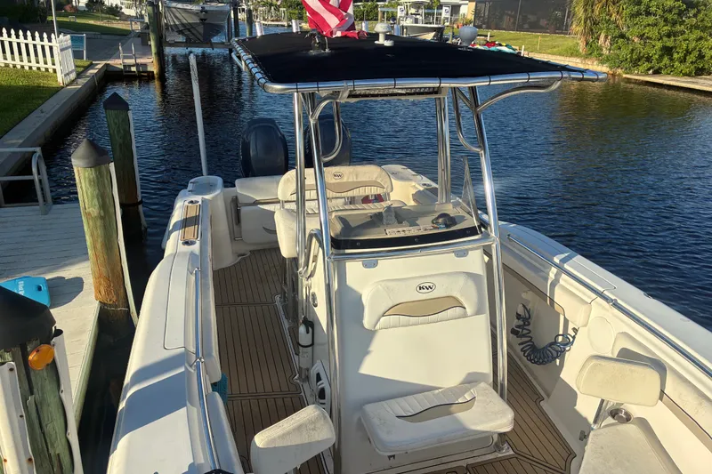 Slide: The Image of 2010 Key West 244 Center Console boat docked by a canal, featuring a sleek design. - 11
