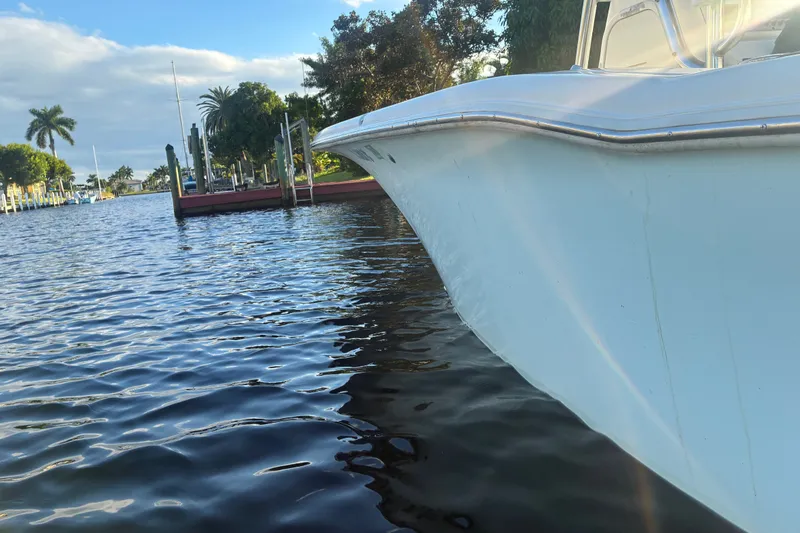 Slide: The Image of 2010 Key West 244 Center Console boat docked on a sunny day, surrounded by calm water. - 51