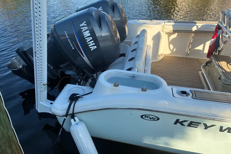 Slide: The Image of 2010 Key West 244 Center Console boat with Yamaha outboard engines docked on calm water. - 21