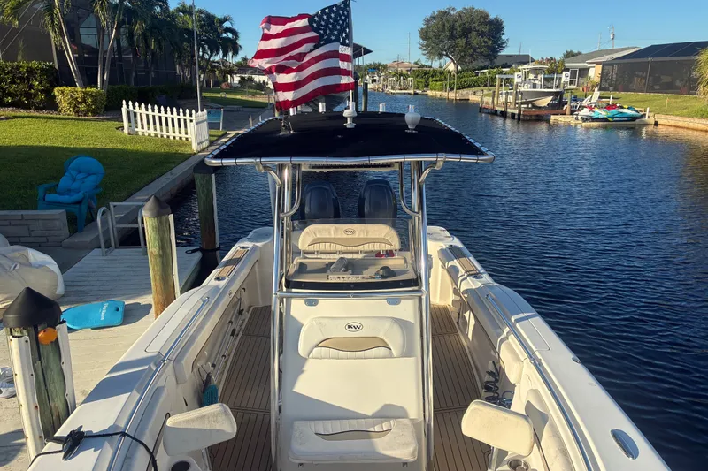 Slide: The Image of 2010 Key West 244 Center Console boat docked by a canal with American flag. - 9
