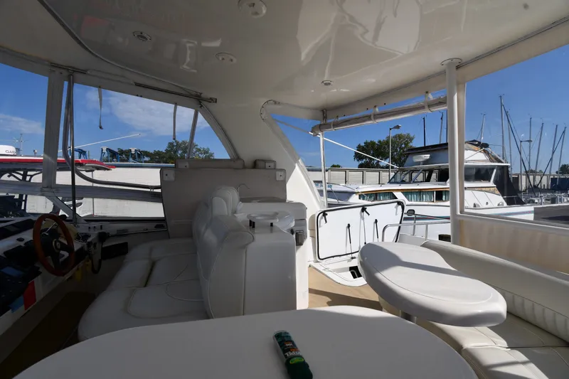 Slide: The Image of Interior view of 2003 Cruisers Yachts 5000 Sedan Sport, featuring seating and helm area. - 30