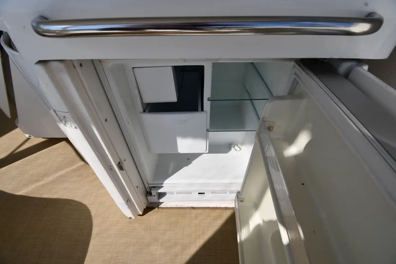Slide: The Image of Open refrigerator inside 2003 Cruisers Yachts 5000 Sedan Sport, showcasing interior storage space. - 32