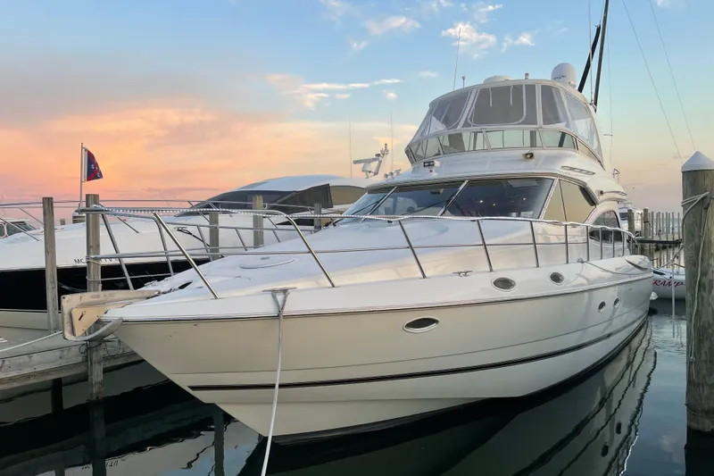 Slide: The Image of 2003 Cruisers Yachts 5000 Sedan Sport docked at sunset, showcasing sleek design and luxury. - 2