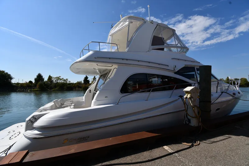 The Image of 2003 Cruisers Yachts 5000 Sedan Sport docked by a serene waterfront. - 0
