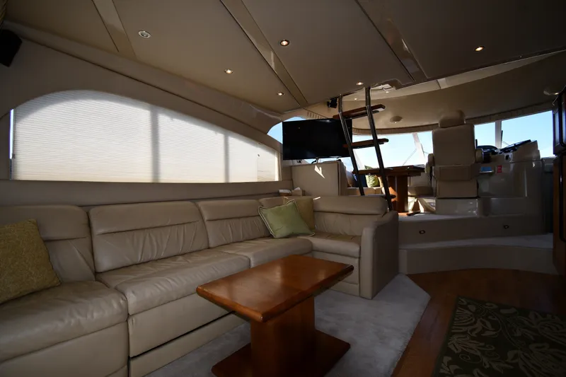 Slide: The Image of Luxurious interior of 2003 Cruisers Yachts 5000 Sedan Sport with leather seating and wooden table. - 59