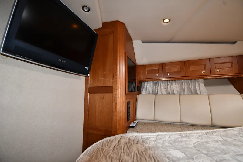 Slide: The Image of Interior of 2003 Cruisers Yachts 5000 Sedan Sport with TV, wood cabinets, and beige seating. - 39