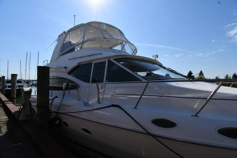 Slide: The Image of 2003 Cruisers Yachts 5000 Sedan Sport docked under clear blue sky. - 5